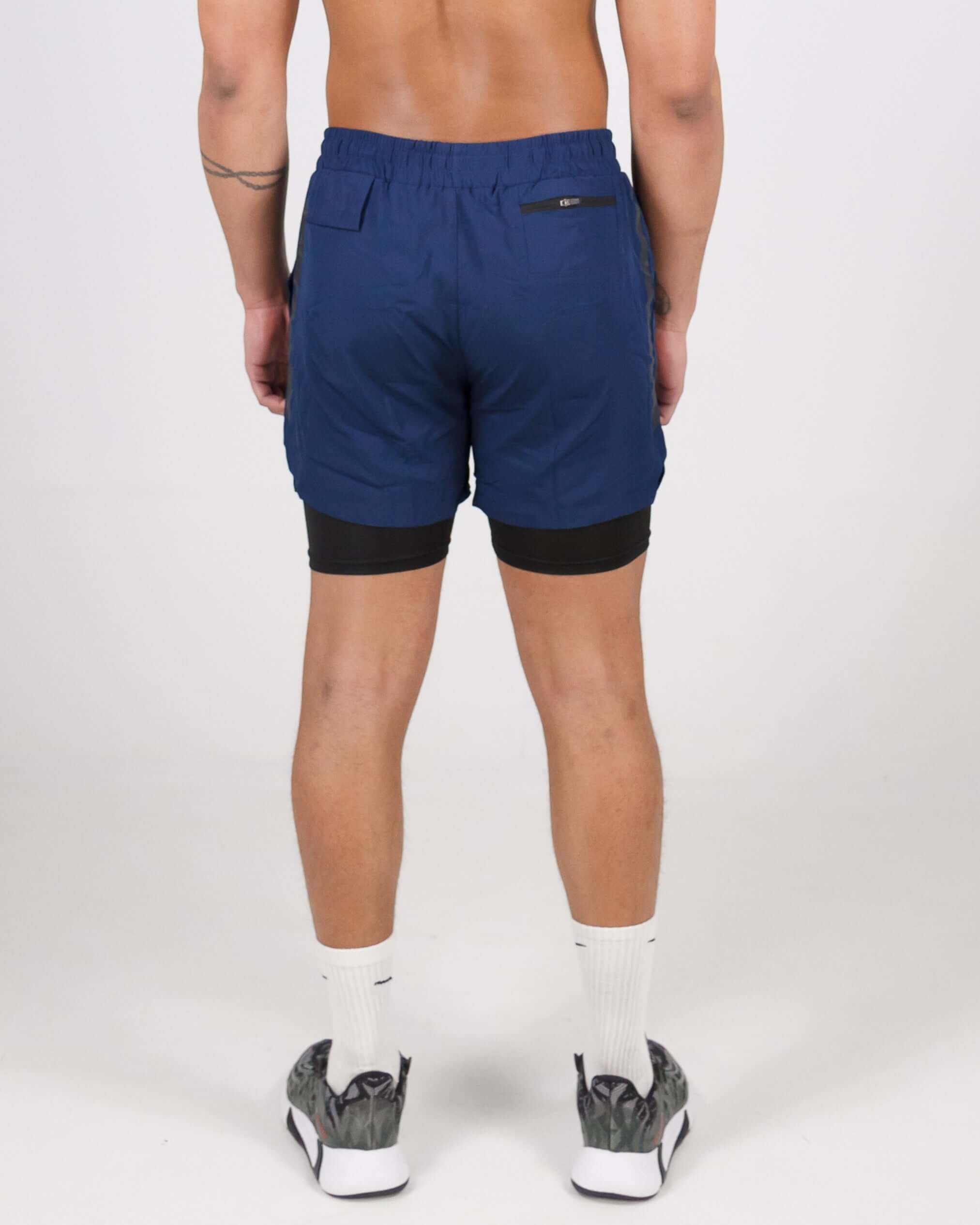 Back view of man wearing navy blue Pinnacle Dry-Fit 2-in-1 Shorts showcasing innovative compression support