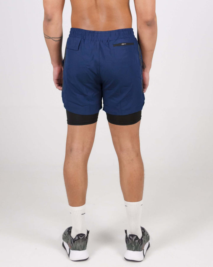 Back view of man wearing navy blue Pinnacle Dry-Fit 2-in-1 Shorts showcasing innovative compression support