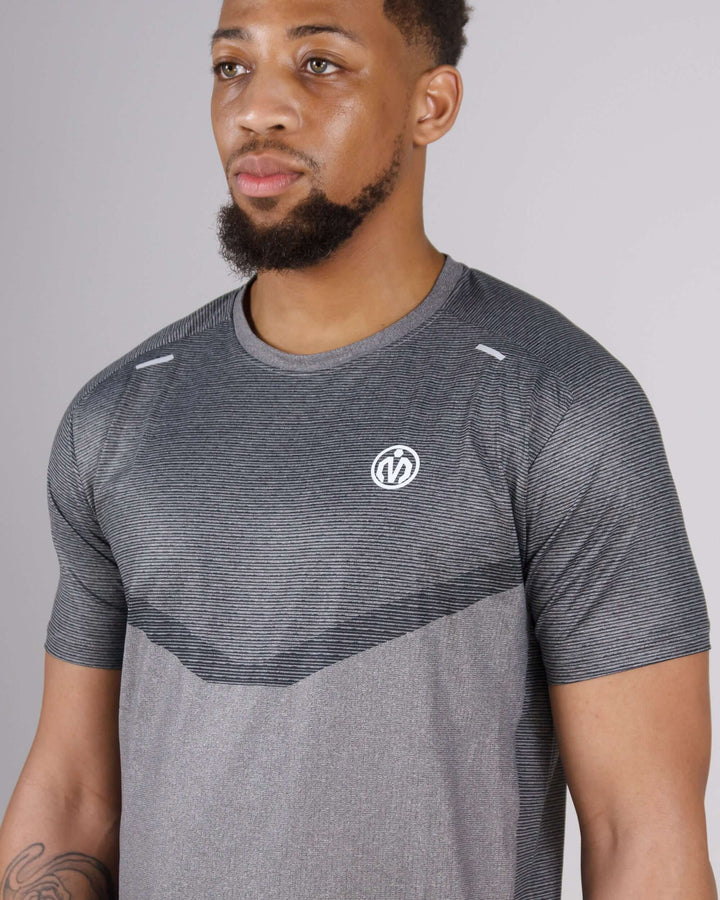 Man wearing MEM Pinnacle Dry-Fit Training Top in dark grey, designed for peak performance with sweat-wicking technology.