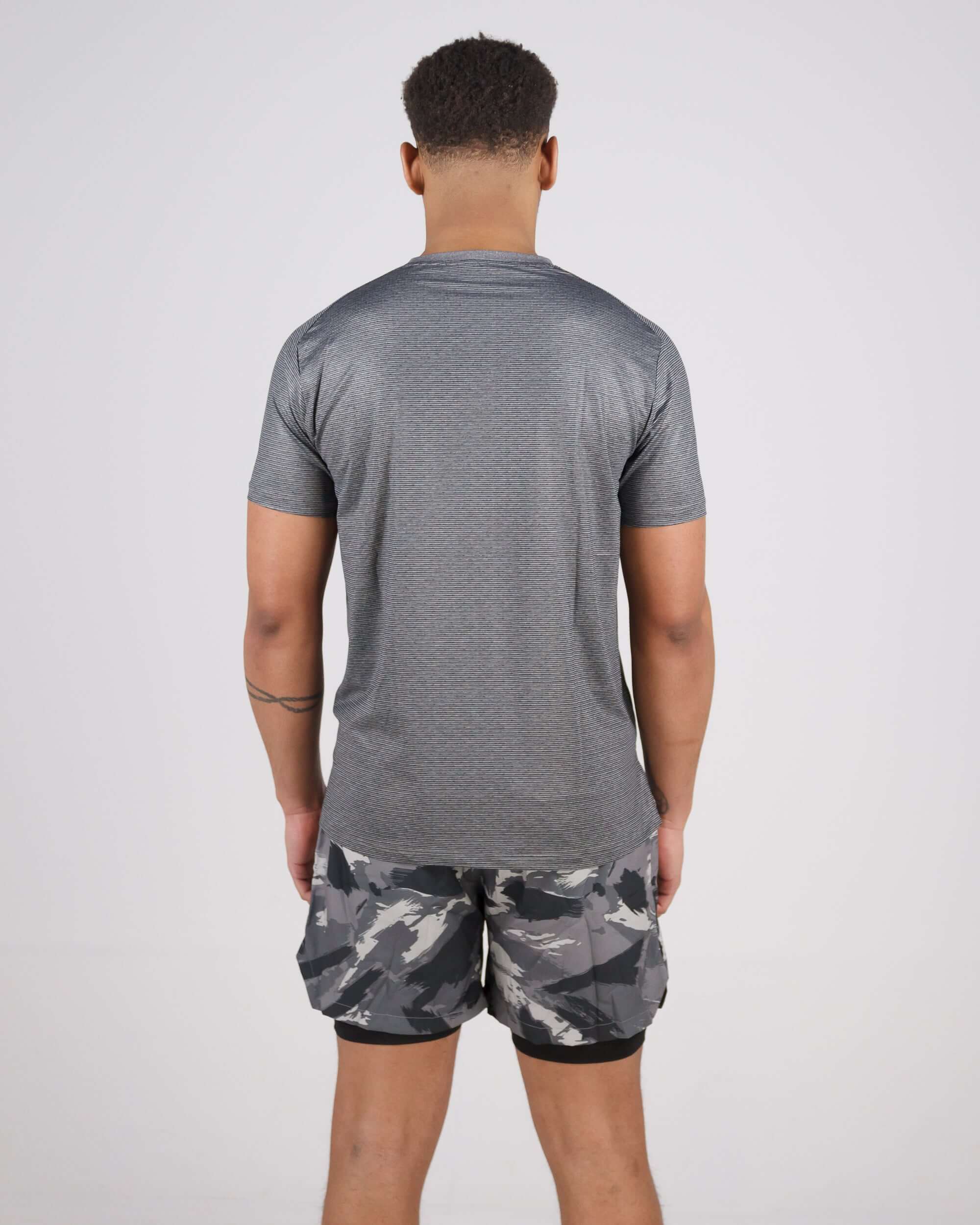 Back view of a person wearing a Pinnacle Dry-Fit T-Shirt paired with camo shorts.