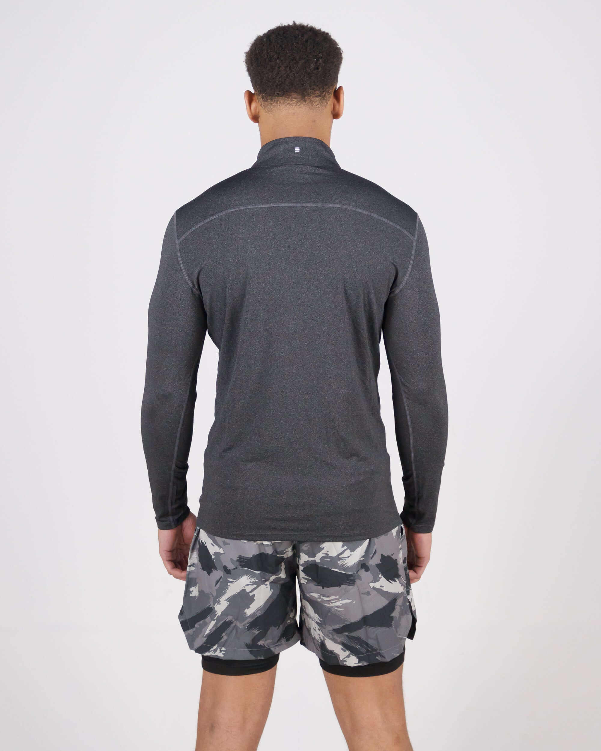 Back view of a man wearing a grey Pinnacle Dry-Fit Long Sleeve Half Zip Training Top and camo shorts.