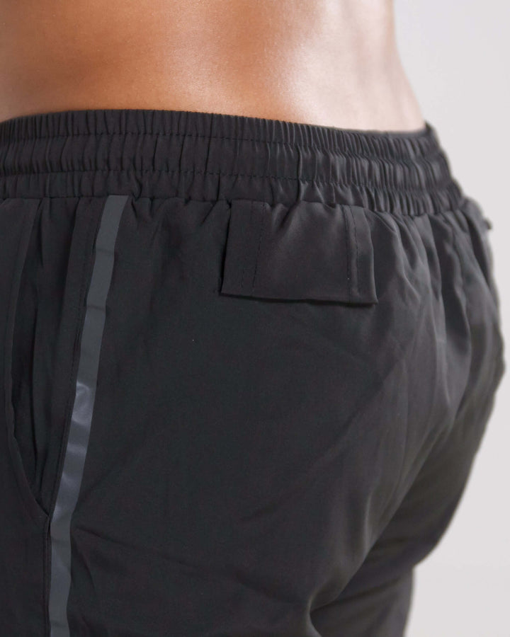 Close-up view of black Pinnacle Dry-Fit 2-in-1 shorts highlighting elastic waistband and side detail.