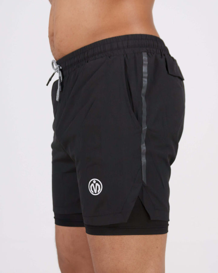 Black Pinnacle Dry-Fit 2-in-1 Shorts offering compression support, modeled to showcase performance-enhancing athletic wear