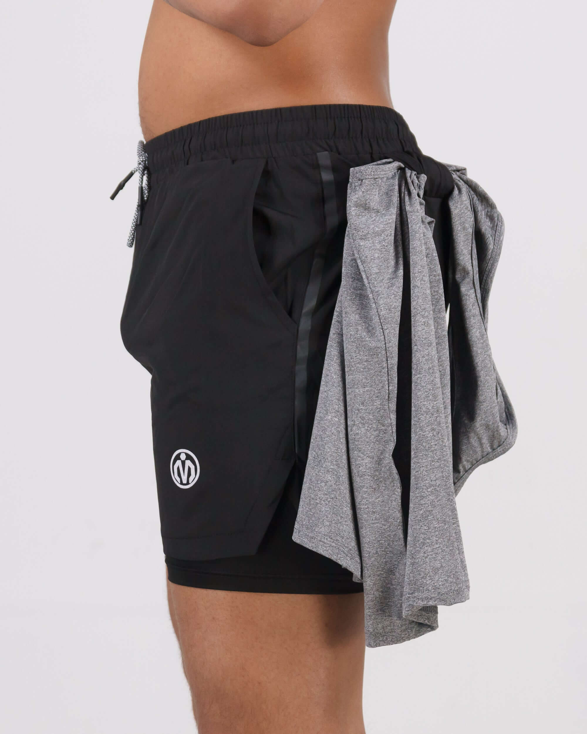 Close-up side view of black Pinnacle Dry-Fit 2-in-1 Shorts featuring 2-in-1 compression support design with gray towel attached.