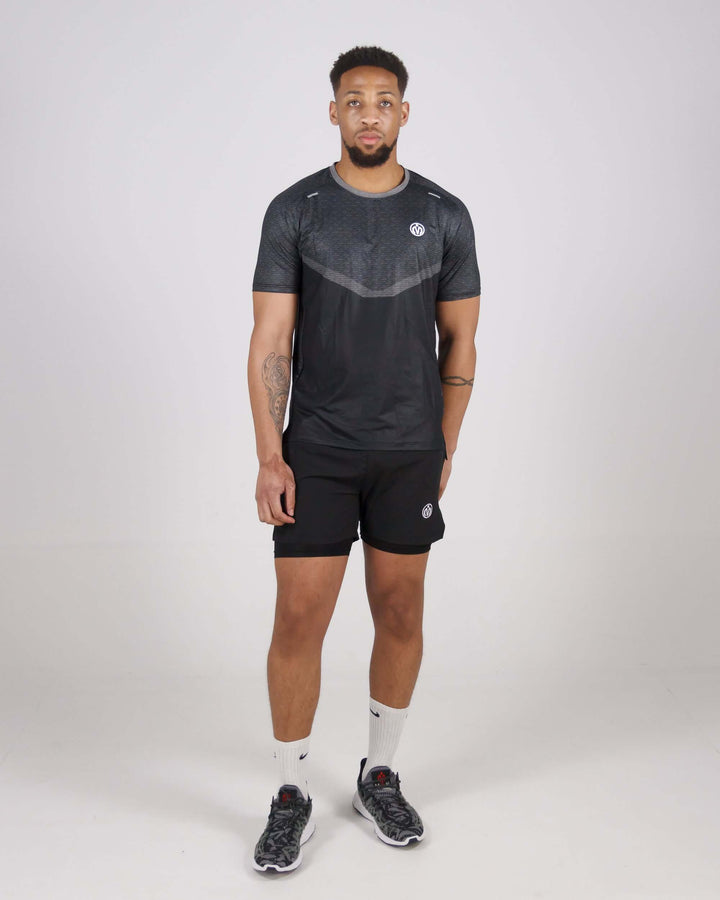 Man wearing Pinnacle Dry-Fit T-Shirt and shorts, showcasing athletic apparel for training.