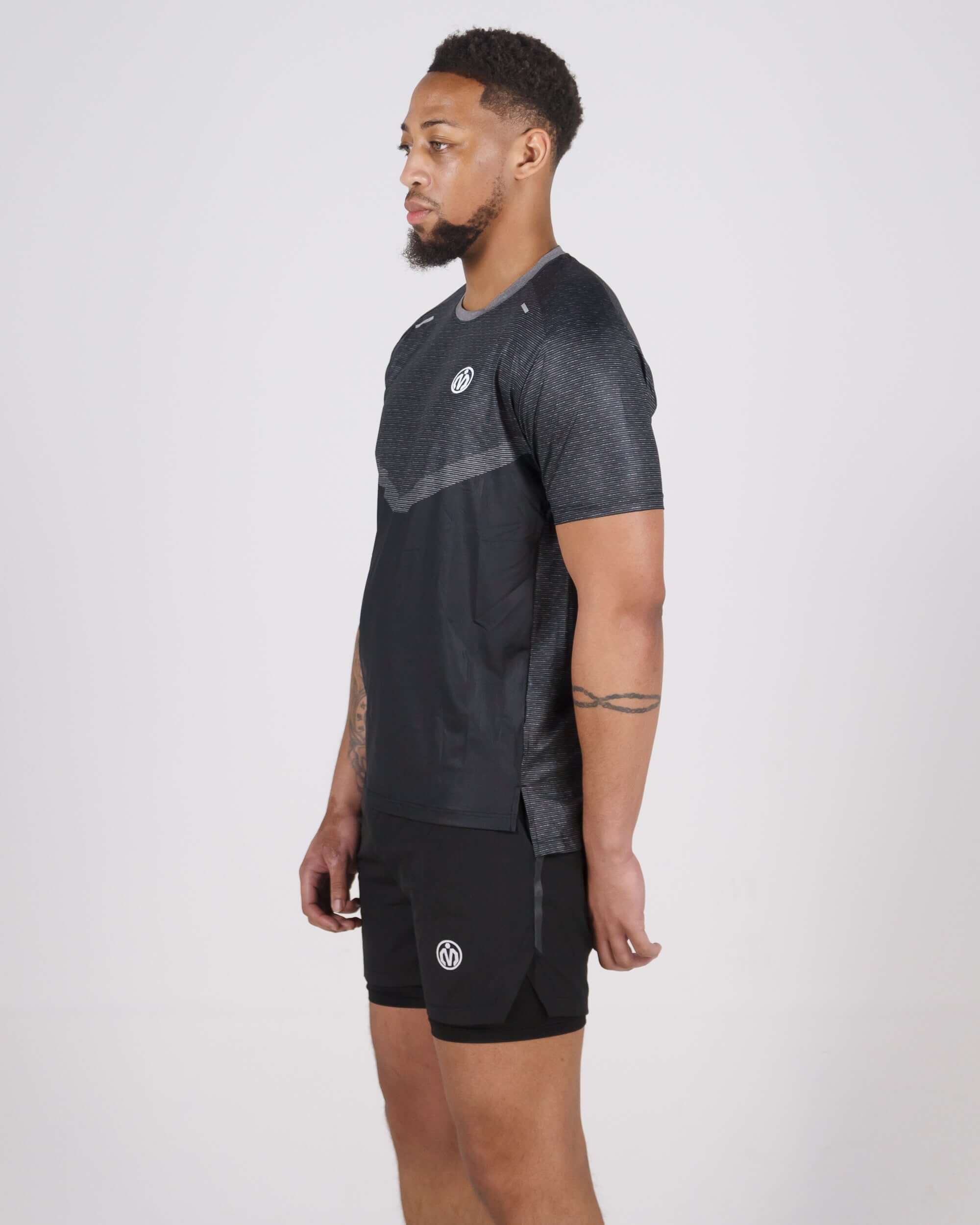 Man wearing black Pinnacle Dry-Fit T-Shirt, ideal for intense training with sweat-wicking technology and lightweight design.