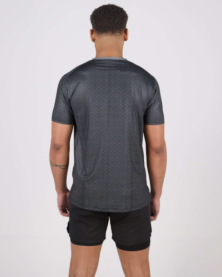 Man wearing Pinnacle Dry-Fit T-Shirt in black, viewed from the back, showcasing ultra-lightweight and sweat-wicking fabric.